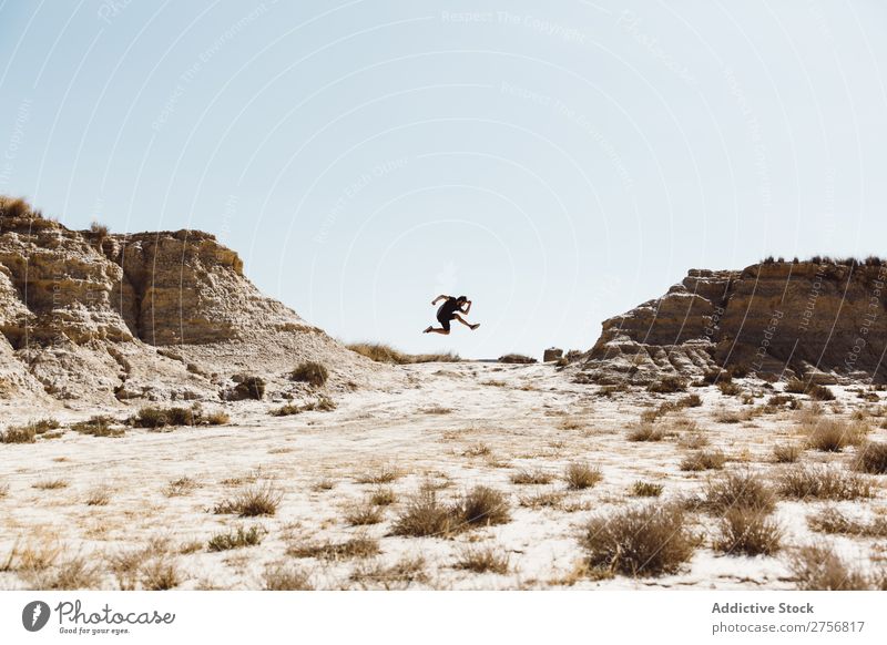 Anonymer Mann, der auf die Wüste springt. Klippe Ferien & Urlaub & Reisen Lifestyle Mensch Erwachsene Natur Abenteuer Ausflug Tourist Sonnenstrahlen genießend