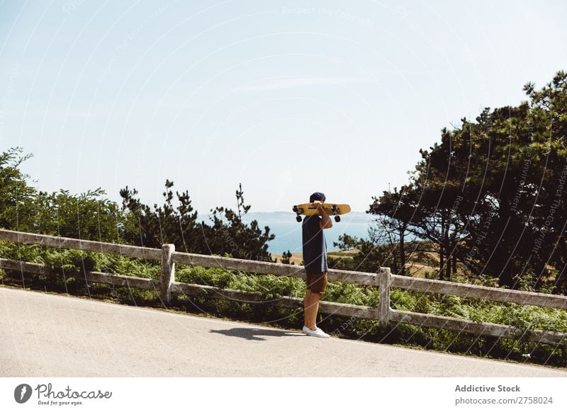 Mann mit Skateboard am Zaun Skateboarderin Reiten Asphalt Seeküste Sport Lifestyle Schlittschuhlaufen Skateboarding Schlittschuhe extrem Sonnenstrahlen