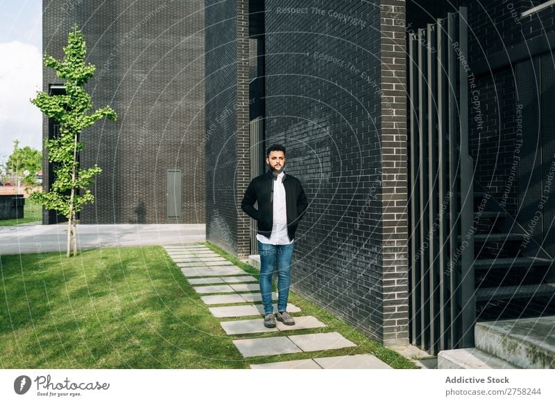 Modischer junger Mann auf der Straße Wegsehen nachdenklich besinnlich stylisch Baustein Wand Stehen selbstbewusst cool Person Porträt modern Model modisch