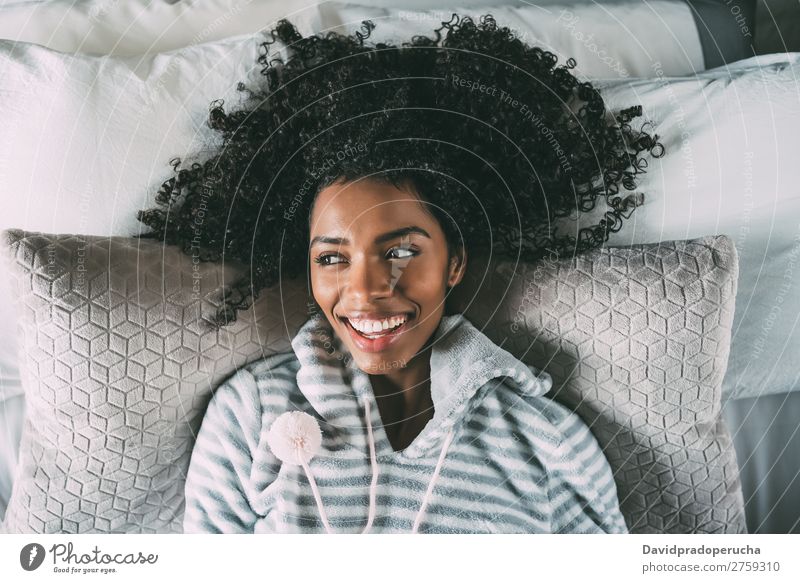 Schöne schwarze Frau, die auf dem Bett liegt und auf die Kamera schaut, die lächelt. Fürsorge Lächeln Afrikanisch hübsch schön Vogelperspektive Nahaufnahme