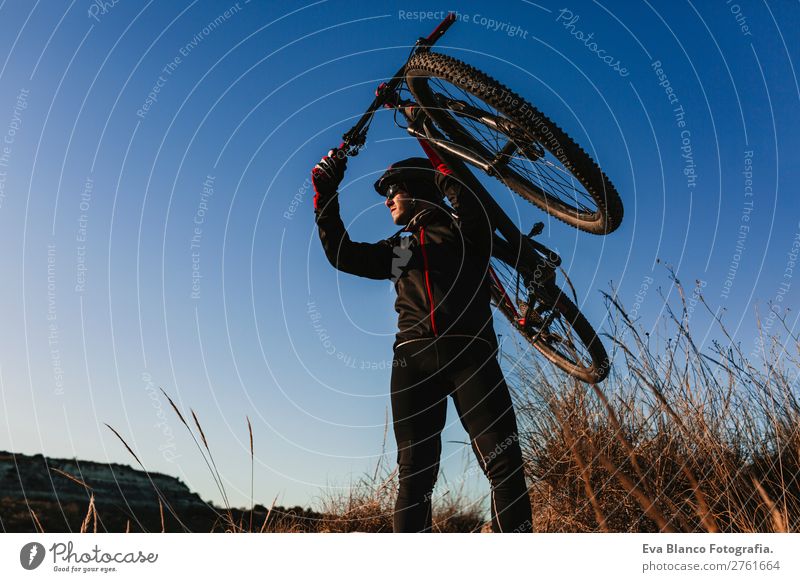 Radfahrer, der das Fahrrad bei Sonnenuntergang hält. Sport Lifestyle Erholung Freizeit & Hobby Abenteuer Sommer Berge u. Gebirge Fahrradfahren maskulin
