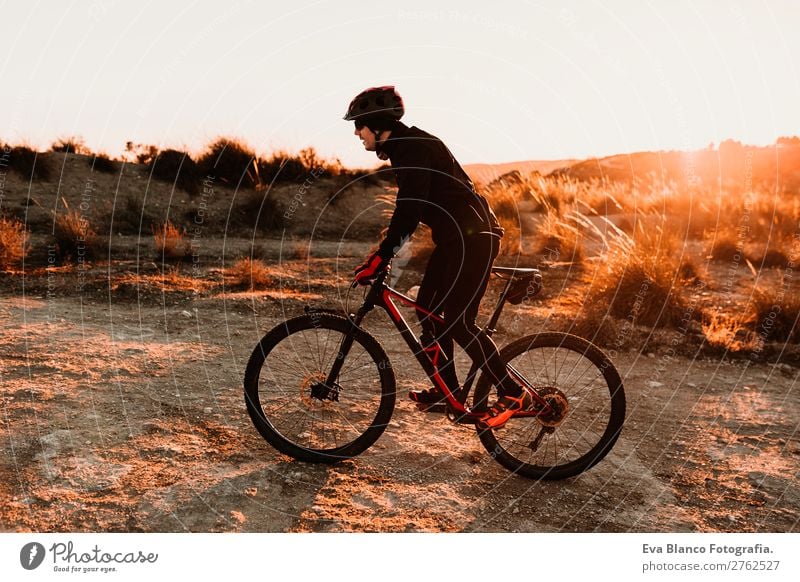 Radfahrer mit dem Fahrrad bei Sonnenuntergang. Sport Lifestyle Erholung Freizeit & Hobby Abenteuer Sommer Berge u. Gebirge Fahrradfahren maskulin Junger Mann