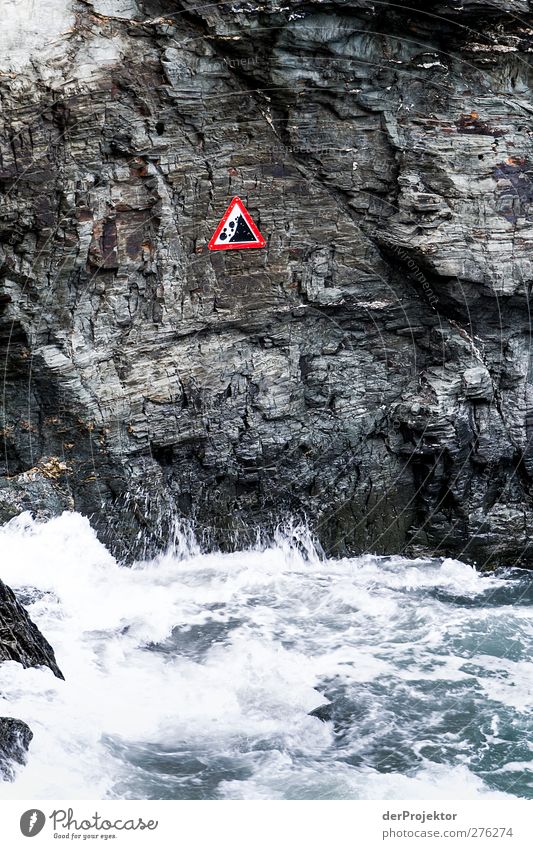 Vorsicht: Steinschlag Natur Pflanze Wasser schlechtes Wetter Wind Regen Wellen Küste Aggression bedrohlich dunkel Kraft Felsen Warnschild Hinweisschild Gischt