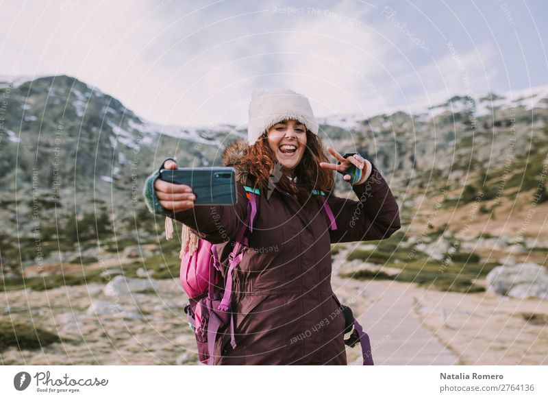 Brünettes Mädchen mit ihrem Rucksack macht sie ein Foto. Lifestyle Glück Ferien & Urlaub & Reisen Tourismus Ausflug Abenteuer Freiheit Berge u. Gebirge Telefon