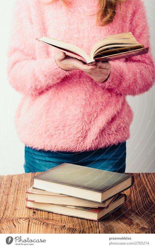 Junges Mädchen mit einem Buch, das im Buchladen steht. Lifestyle Erholung Freizeit & Hobby lesen Schule lernen Mensch Frau Erwachsene Jugendliche 1 Bibliothek