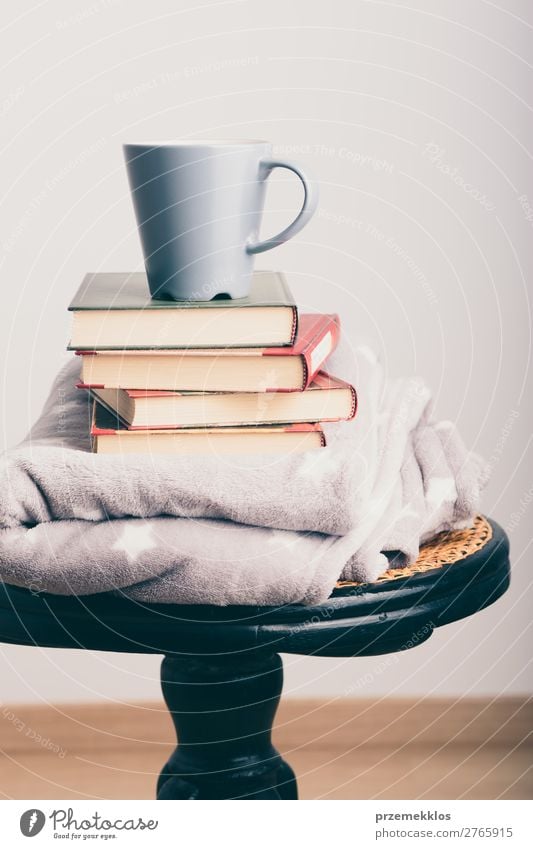 Ein paar Bücher mit Tasse Kaffee und Decke auf Holzstuhl Becher Lifestyle Erholung Freizeit & Hobby lesen Stuhl Buch genießen Geborgenheit bequem gemütlich