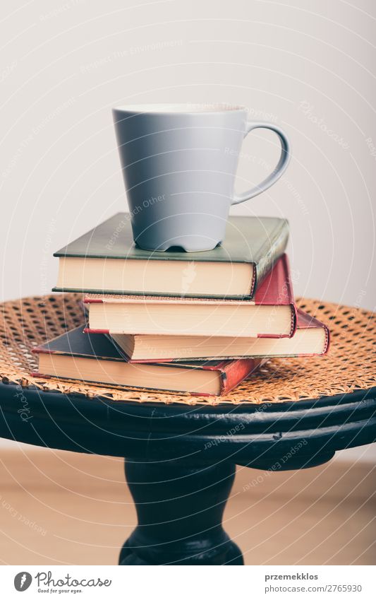 Ein paar Bücher mit einer Tasse Kaffee auf dem Stuhl Becher Lifestyle Erholung Freizeit & Hobby lesen Tisch Buch genießen braun Geborgenheit bequem gemütlich