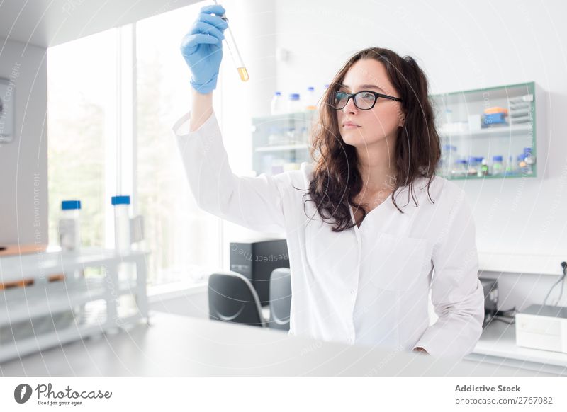 Frau, die auf das Reagenzglas schaut. Labor Arbeit & Erwerbstätigkeit Wissenschaften Reaktionen u. Effekte beobachten Mensch forschen Wissenschaftler Medikament