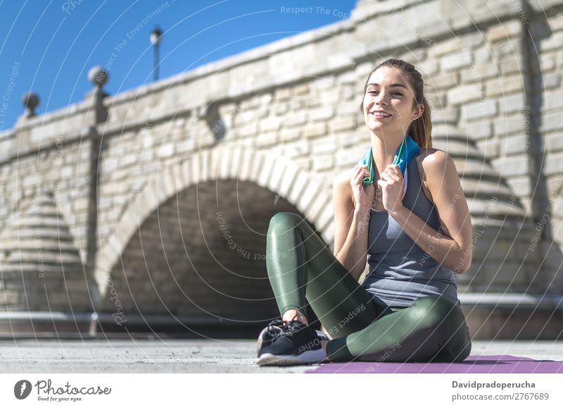 Frau ruht sich aus und trinkt Wasser mit Handtuch nach dem Training. Lifestyle schön Körper Erholung Meditation Sport Yoga Mensch Erwachsene Natur Wärme Park