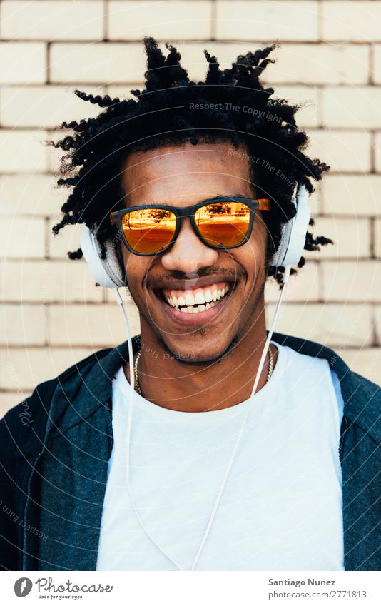 Porträt eines afro-ansehnlichen Mannes, der Musik hört. Jugendliche Afrikanisch schwarz Mulatte Afro-Look Kopfhörer Mobile hören Telefon Lifestyle stehen PDA