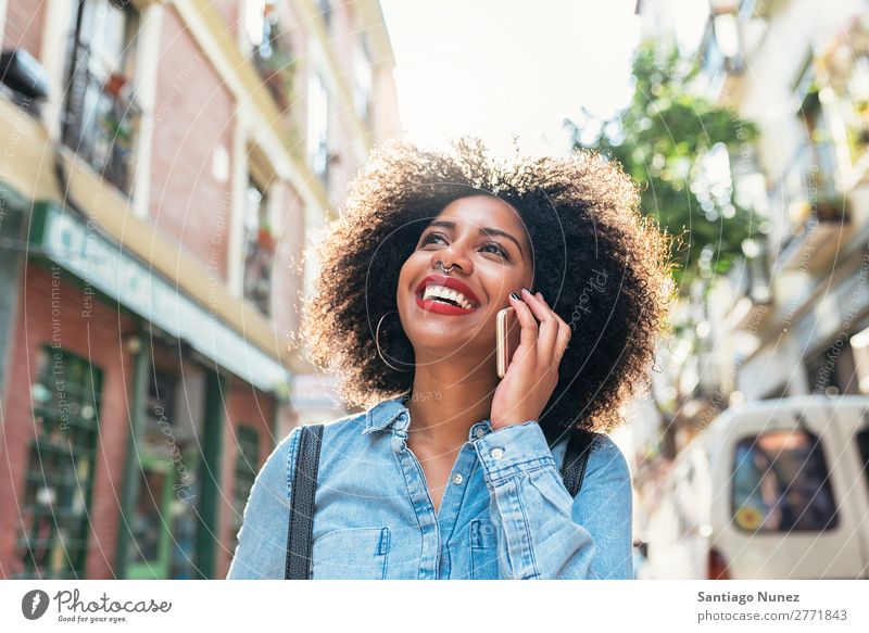 Schöne afroamerikanische Frau, die ihr Handy auf der Straße benutzt. schwarz Afrikanisch Afro-Look Mensch Porträt PDA Jugendliche Mobile Telefon sprechen