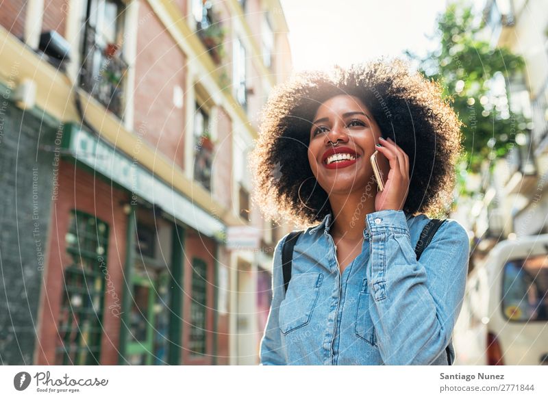 Schöne afroamerikanische Frau, die ein Handy auf der Straße benutzt. schwarz Afrikanisch Afro-Look Mensch Porträt PDA Jugendliche Mobile Telefon sprechen