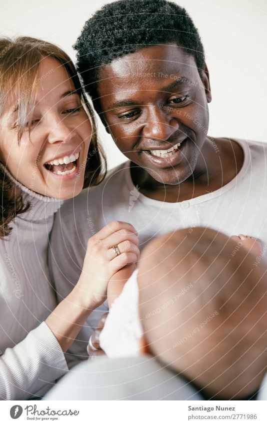 Glückliche Familie, Mutter, Vater und Baby. Junge Kind Bett Mädchen lügen neugeboren Familie & Verwandtschaft Eltern multiethnisch Afrikanisch vielfältig Mensch