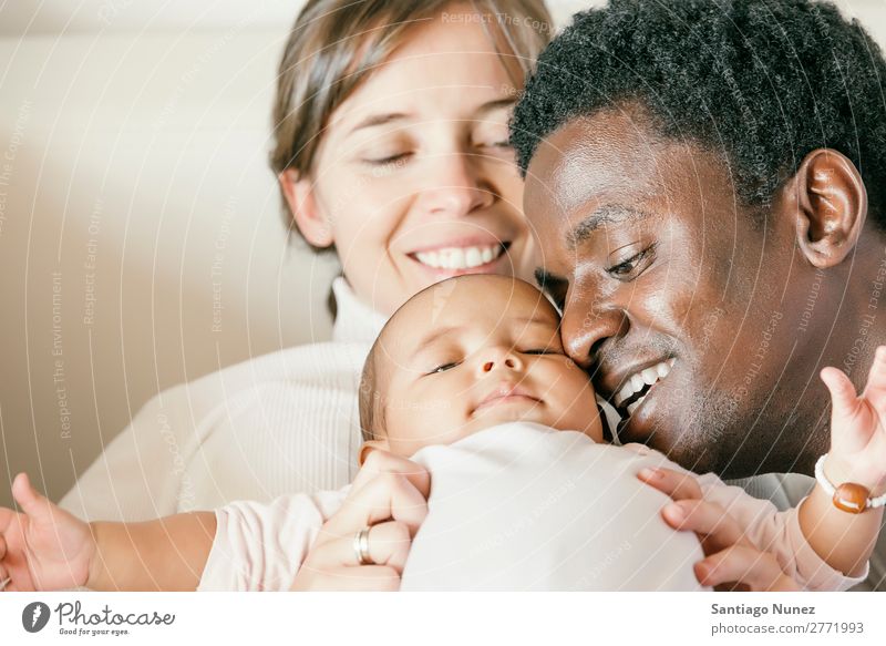 Glückliche Familie, Mutter, Vater und Baby. Junge Kind Familie & Verwandtschaft Liebe Küssen Bett Mädchen lügen neugeboren Eltern multiethnisch Afrikanisch
