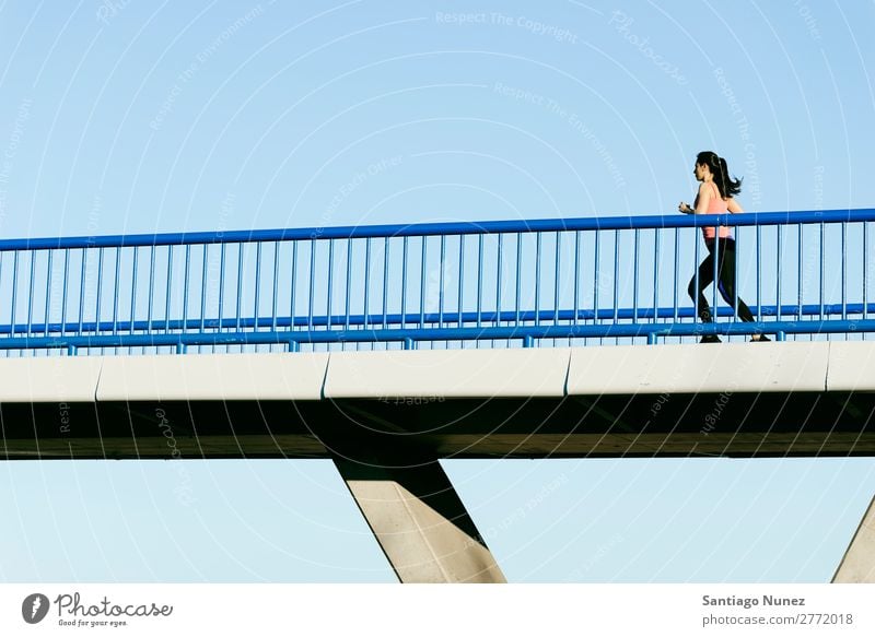 Junge Fitness-Läuferin, die auf der Stadtbrücke läuft. rennen Aktion Athlet sportlich Eisenbahn Frau Training üben Sport stark Körper anstrengen Mobile Telefon