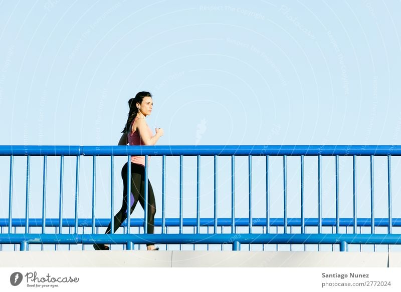 Junge Fitness-Läuferin, die auf der Stadtbrücke läuft. rennen Aktion Athlet sportlich Eisenbahn Frau Training üben Sport stark Körper anstrengen Mobile Telefon