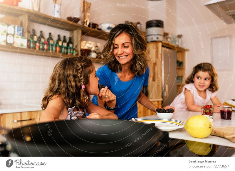 Kleine Schwestern kochen mit ihrer Mutter in der Küche. Kind Mädchen kochen & garen Verkostung Koch Schokolade Speiseeis Tochter Tag Glück Freude