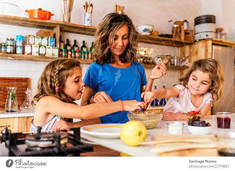 Kleine Schwestern kochen mit ihrer Mutter in der Küche. Kind Mädchen kochen & garen Koch Schokolade Speiseeis Tochter Tag Glück Freude Familie & Verwandtschaft