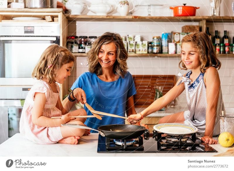 Kleine Schwestern kochen mit ihrer Mutter in der Küche. Kind Mädchen kochen & garen Koch Schokolade Speiseeis Tochter Tag Glück Freude Familie & Verwandtschaft