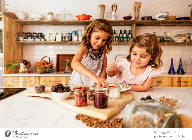 Kleine Schwestern Mädchen bereitet das Backen von Keksen vor. Kind kochen & garen Koch Küche Schokolade Speiseeis Erdbeeren Tochter Tag Glück Freude