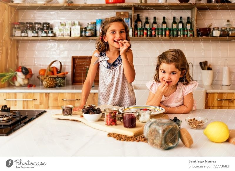 Kleine Schwestern Mädchen bereitet das Backen von Keksen vor. Kind kochen & garen Koch Küche Schokolade Essen Verkostung Erdbeeren Tochter Tag Glück Freude