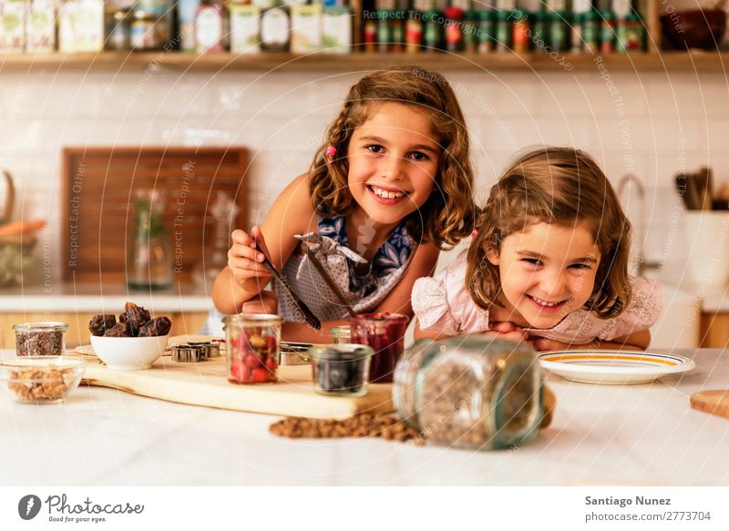 Kleine Schwestern Mädchen bereitet das Backen von Keksen vor. Kind kochen & garen Koch Küche Schokolade Mehl dreckig gefärbt lachen Tochter Tag Glück Freude