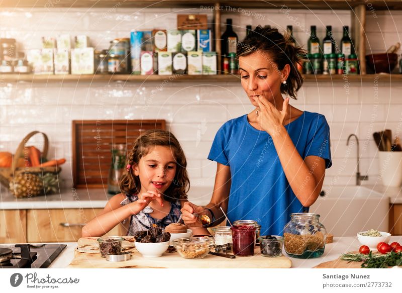 Kleines Mädchen kocht mit ihrer Mutter in der Küche. kochen & garen Koch Schokolade Verkostung Tochter Tag Glück Freude Familie & Verwandtschaft Liebe backen
