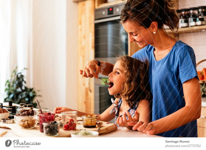 Kleines Mädchen kocht mit ihrer Mutter in der Küche. kochen & garen Koch Schokolade Verkostung Tochter Tag Glück Freude Familie & Verwandtschaft Liebe backen