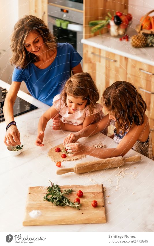 Kleine Schwestern kochen mit ihrer Mutter in der Küche. Kind Mädchen kochen & garen Koch Tomate Pizza Gemüse Tochter Aufstrich Tag Glück Freude
