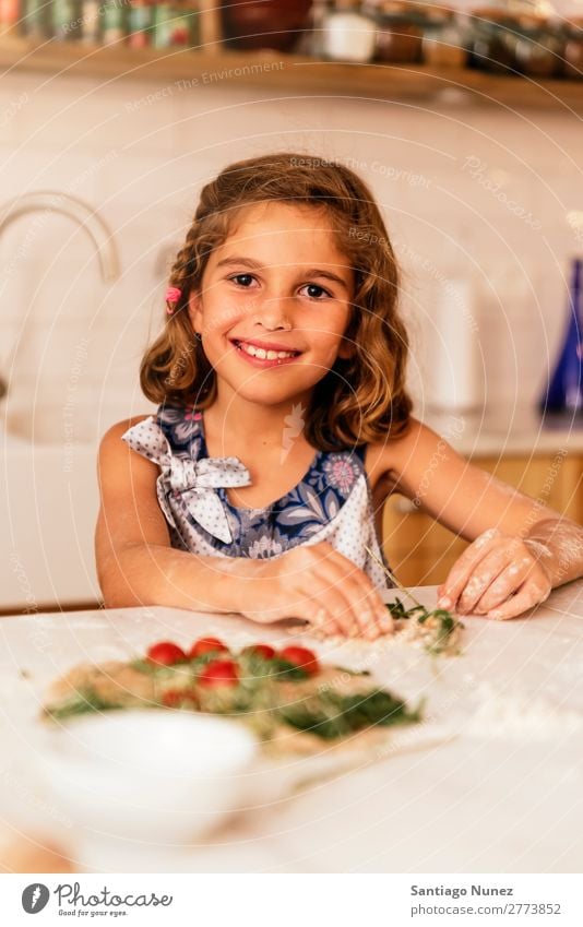 Porträt eines kleinen Mädchens beim Backen von Keksen. Kind Ernährung Fressen Verkostung Essen genießend Mehl Teigwaren Appetit & Hunger Lächeln lachen