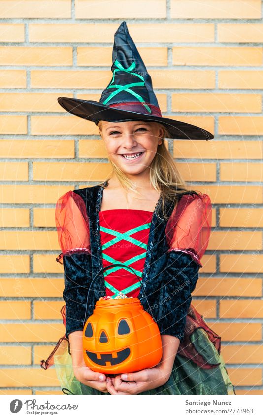 Porträt eines schönen Mädchens, das sich als Hexe auf der Straße verkleidet hat. Halloween Kind malen Freude Familie & Verwandtschaft Schwester Kürbis Angst