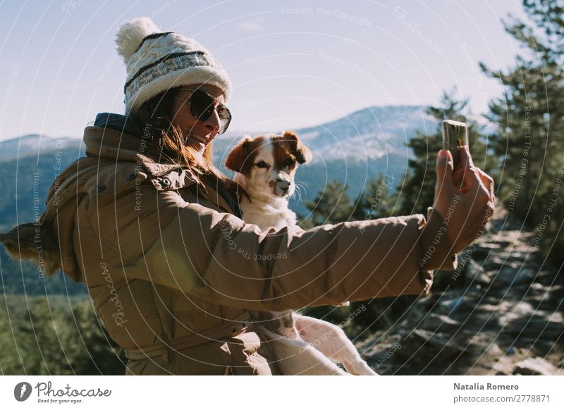 Mädchen macht einen Selfie mit ihrem Haustier im Berg. Lifestyle Freizeit & Hobby Abenteuer Freiheit Schnee Berge u. Gebirge wandern Fotokamera