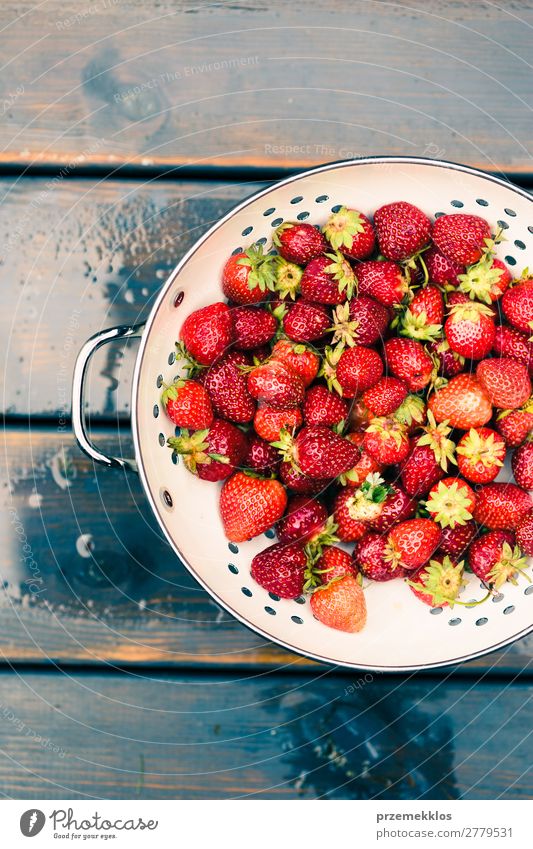 Schüssel mit frischen Erdbeeren besprüht Regentropfen auf Holztisch Frucht Vegetarische Ernährung Schalen & Schüsseln Sommer Tisch Natur lecker natürlich saftig