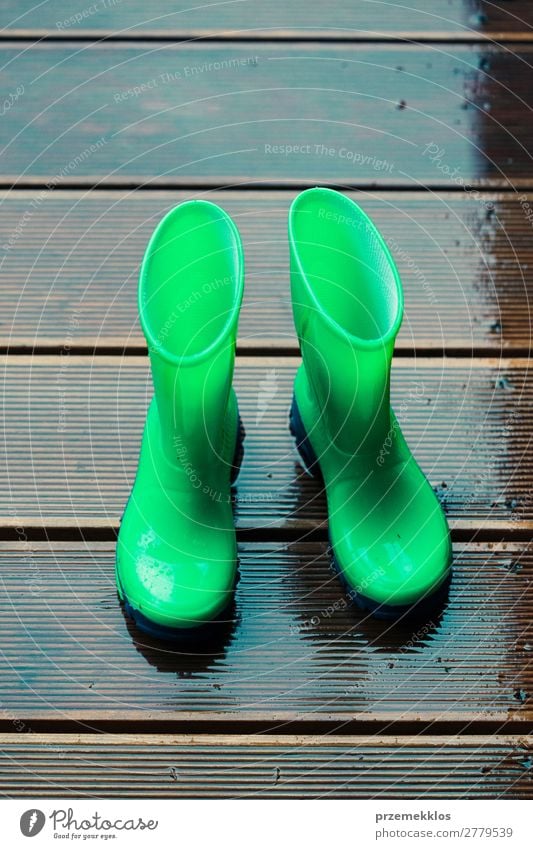 Regenstiefel, die auf einer Holzterrasse stehen, während es regnet. Freude Sommer Kind Mensch Frau Erwachsene Mann Wetter Mantel Schuhe Stiefel Gummistiefel