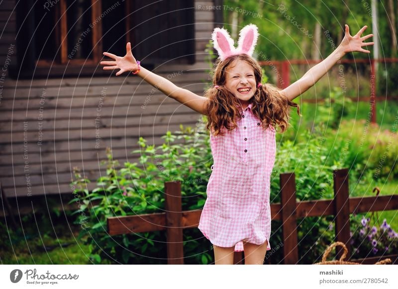 Osterporträt eines glücklichen Kindes Mädchen in Hasenohren Freude Spielen Haus Garten Feste & Feiern Ostern Familie & Verwandtschaft Kindheit Natur Gras Holz