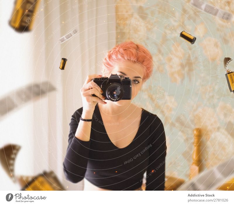 junges Mädchen mit rosa Haaren fotografiert mit Filmkamera Fotokamera Frau Fotografie Porträt Filmmaterial Blick in die Kamera horizontal abstrakt fliegen