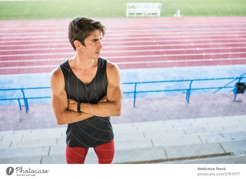 Junger Sportler posiert im Stadion Mann Körperhaltung ruhen Fitness die Hände gekreuzt üben Athlet muskulös Erholung Erwachsene Sprinter Pause Sportbekleidung