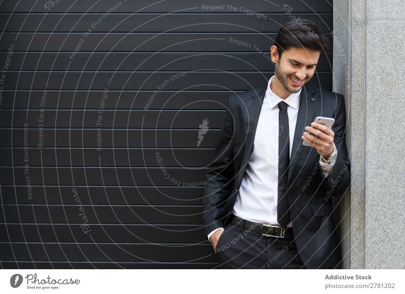 Eleganter junger Geschäftsmann auf der Straße mit dem Handy Mann Business Mode gutaussehend Jugendliche Blick Model Mensch Hintergrundbild Anzug modern