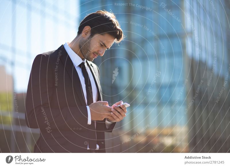Eleganter junger Geschäftsmann auf der Straße mit dem Handy Mann Business Mode gutaussehend Jugendliche Blick Model Mensch Hintergrundbild Anzug modern