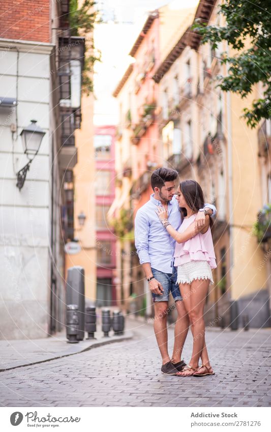 Freund, der seine Freundin auf der Straße umarmt. Paar Romantik Porträt Angesicht zu Angesicht Gebäude Fassade Hintergrundbild lässig Ganzkörperaufnahme