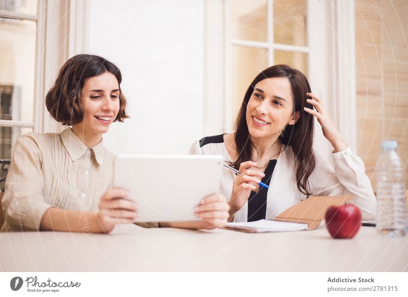 Junge Frauen, die auf das Tablett schauen und lächeln. Lächeln Tablet Computer Mitteilung Technik & Technologie heiter zeigen benutzend Business