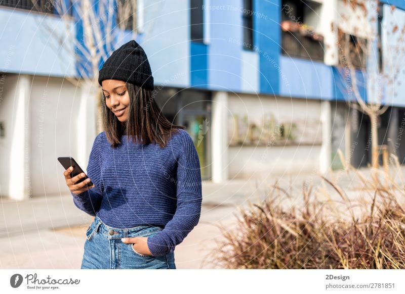 Glückliche Frau mit Hut in der City Street, während sie Technologie einsetzt. Stil schön Haare & Frisuren PDA Technik & Technologie Mensch feminin Junge Frau