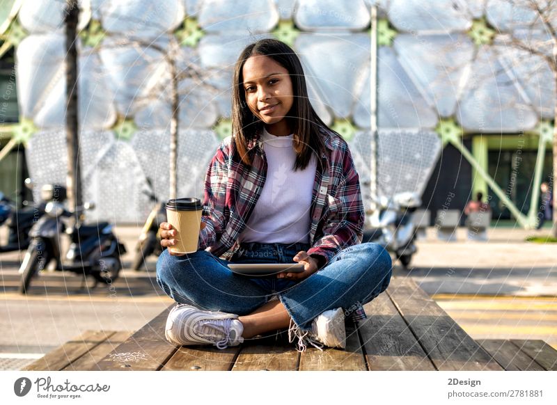 Junge schöne afroamerikanische Frau, die im Freien sitzt. Kaffee Tee Stil Glück Computer Technik & Technologie Internet Mensch feminin Junge Frau Jugendliche