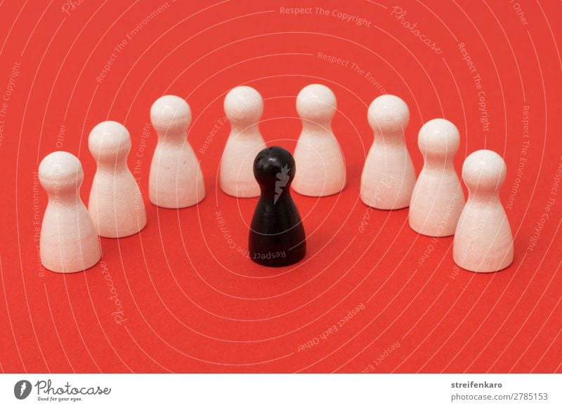 Schwarze Spielfigur steht einem Halbkreis von weißen Spielfiguren gegenüber Spielen sprechen Menschengruppe Spielzeug Holz beobachten Kommunizieren Aggression