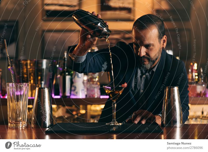 Barman macht Cocktails im Nachtclub. Schüttler Barmann Barkeeper Kellnern Mann rühren Mixologe Hinzufügen Alkohol Business Club trinken professionell Pub