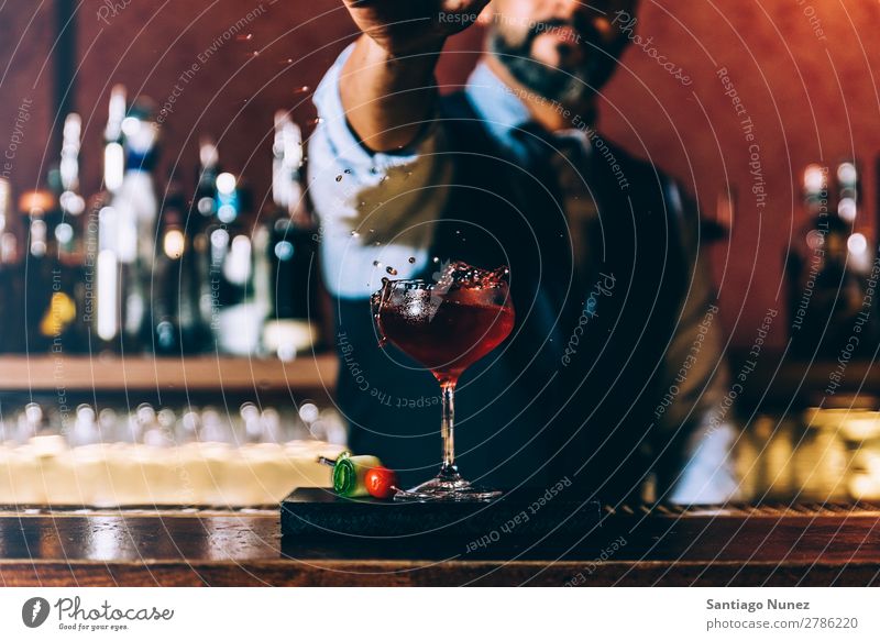 Barman macht Cocktails im Nachtclub. Schüttler Barmann Barkeeper Kellnern Mann rühren Mixologe Hinzufügen Alkohol Business Club platschen Tropfen trinken
