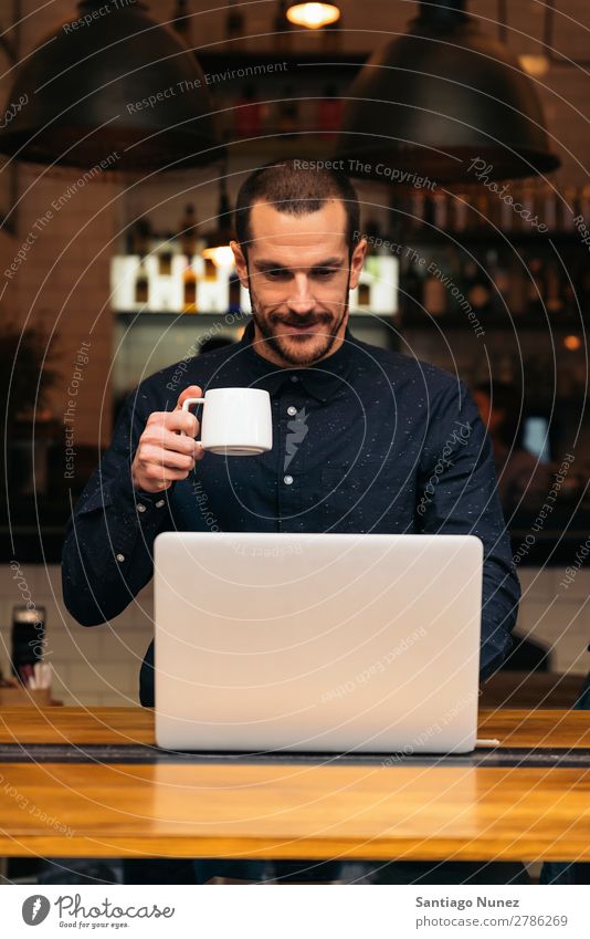 Geschäftsmann mit seinem Laptop im Coffee Shop. Mann Kaffee Freundlichkeit Porträt Jugendliche Mensch Lifestyle Business Mitteilung PDA Handy Mobile benutzend