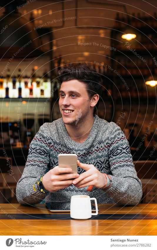 Geschäftsmann mit seinem Handy in der Cafeteria. Mann Kaffee Freundlichkeit Porträt Jugendliche Mensch Lifestyle Business Mitteilung PDA Mobile benutzend Text
