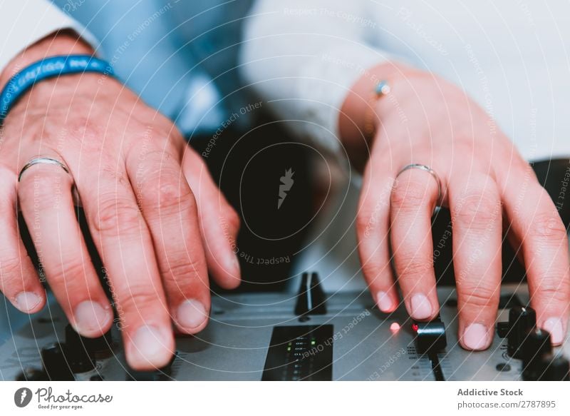 Crop Mann mit Musik-Equalizer benutzend Audio Klang Diskjockey Gerät Hemd Hand Getränk professionell Technik & Technologie Produzent Studioaufnahme elektronisch
