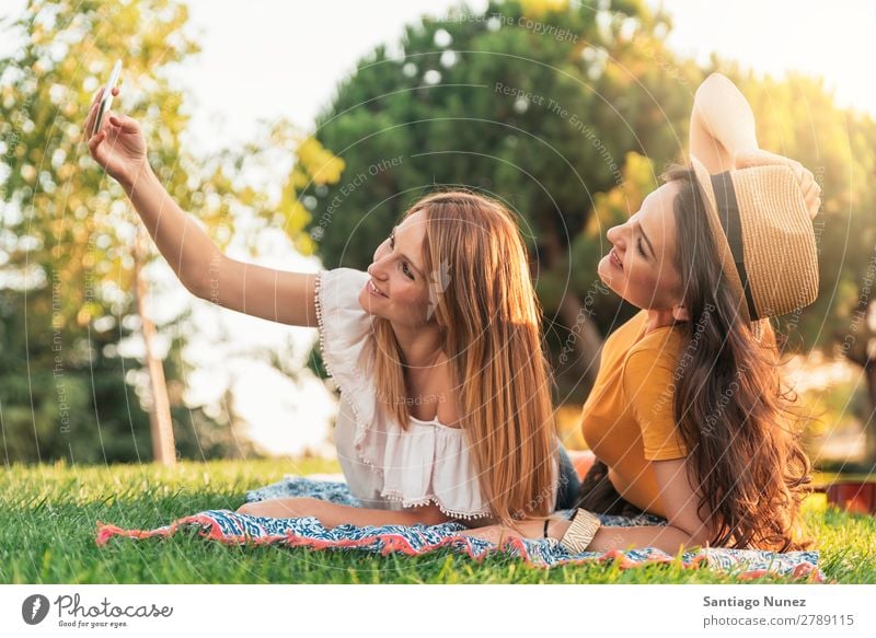 Wunderschöne Frauen, die ein Selbstporträt im Park machen. Picknick Freundschaft Jugendliche Glück Sommer Mensch Freude Mobile PDA Telefon Solarzelle Fotografie